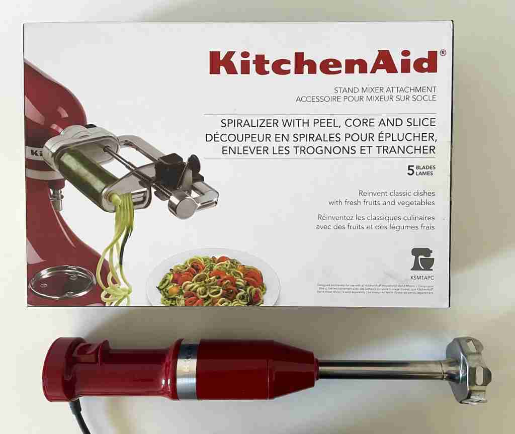 A red Kitchen Aid spiralizer and a red Kitchen Aid immersion blender.