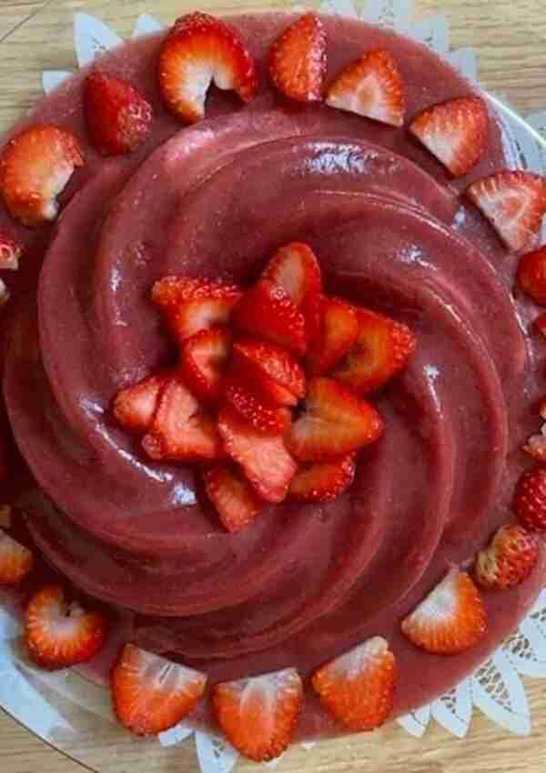 Homemade sugar-free strawberry jello cake with strawberries in the middle and on the sides made in a Nordic Ware Heritage Bundt Cake Pan