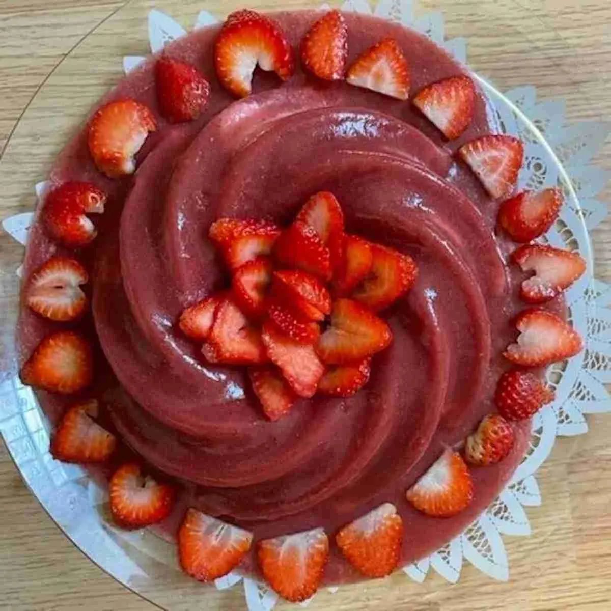 Homemade sugar-free strawberry jello cake with strawberries in the middle and on the sides made in a Nordic Ware Heritage Bundt Cake Pan