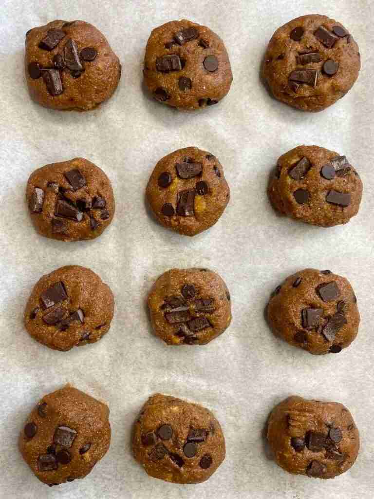 A step in the recipe: unbaked cookies on parchment paper. 