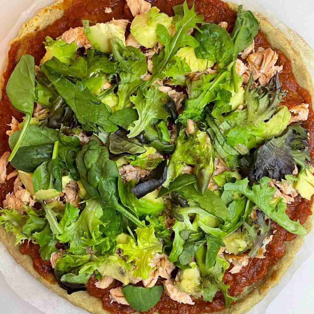 Almond flour pizza dough topped with salmon and avocado