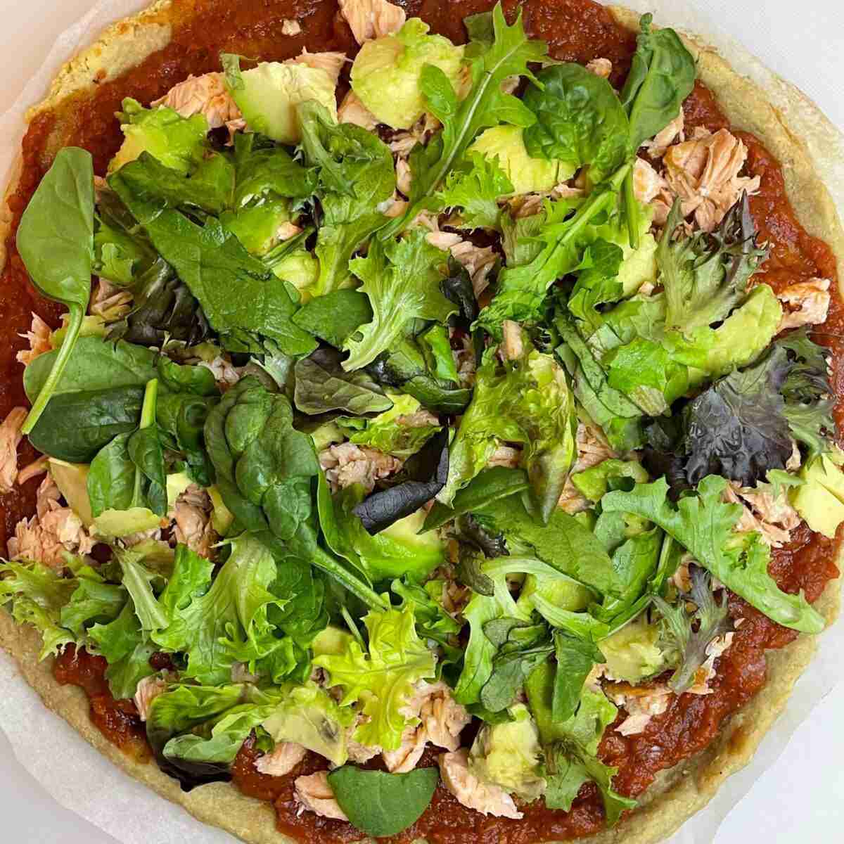 Almond flour pizza dough topped with salmon and avocado