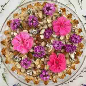 Sugar-free pear pie adorned with flowers and photographed from above.