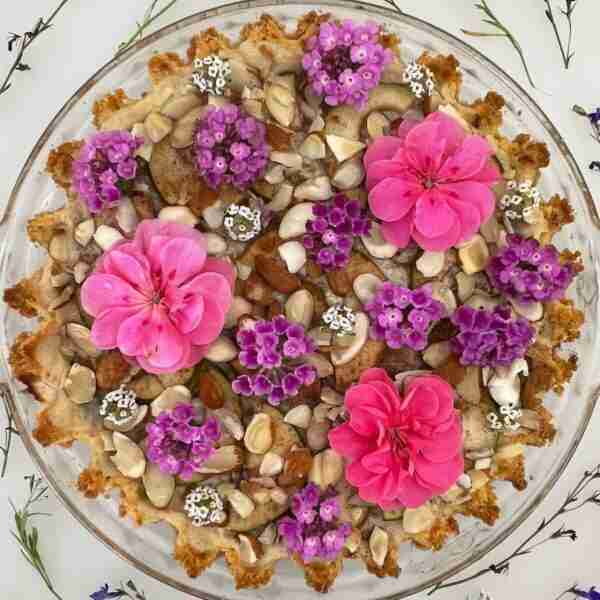 Sugar-free pear pie adorned with flowers and photographed from above.