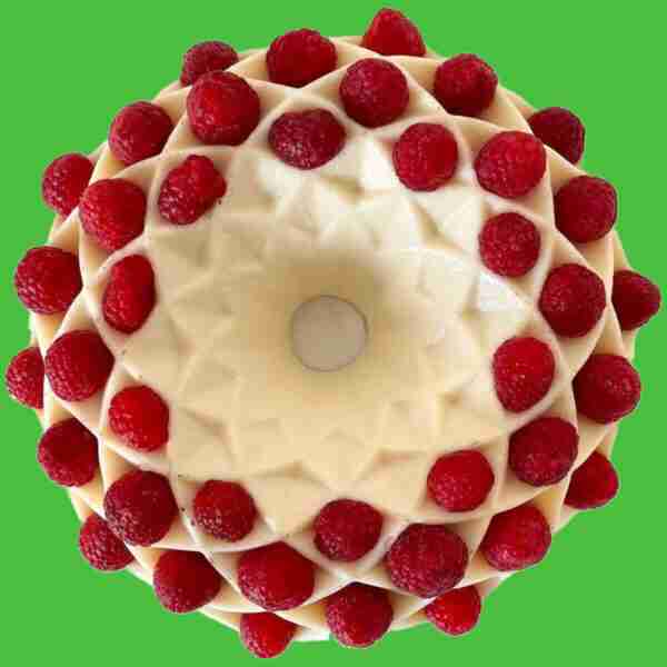 Milk jello made in a bundt cake pan and topped with raspberries.