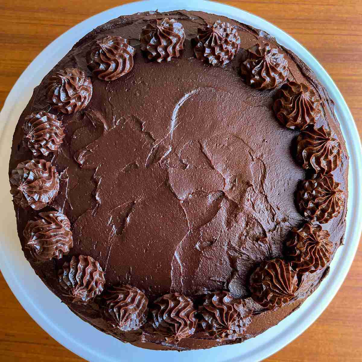 An overhead shot of a healthy vegan Chocolate Ganache Cake with chocolate avocado frosting.