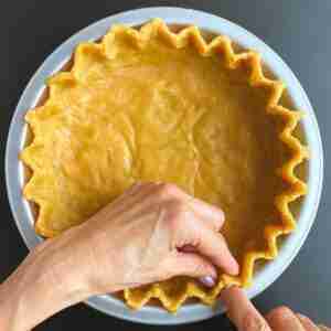 The image illustrates how to flute the edges of the pie.