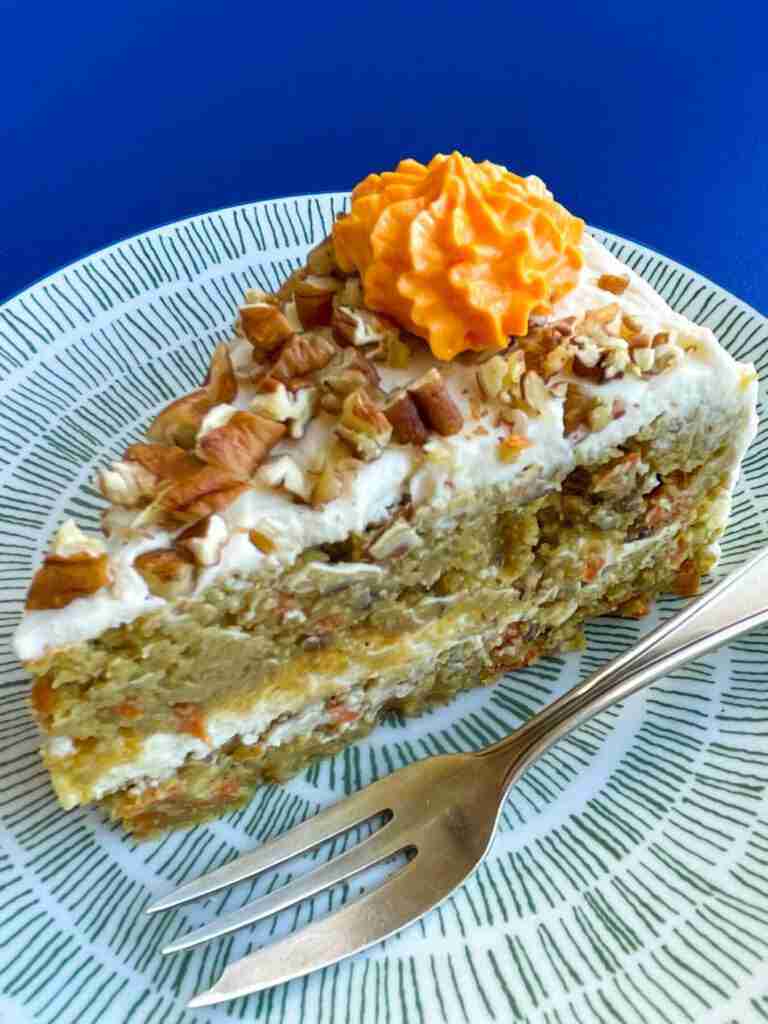 The result of this diabetic carrot cake recipe: A slice of healthy carrot cake with monk fruit that is frosted with keto cream cheese frosting and topped with pecans.