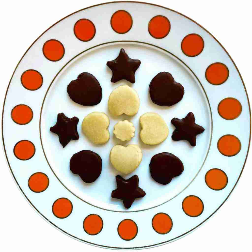 Plain and chocolate-covered marzipan cookies on a platter.