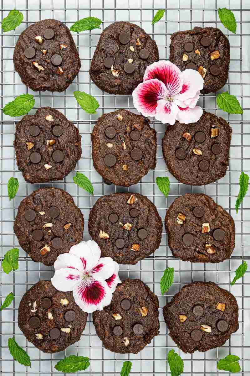 Flourless chocolate chip pecan cookies with mint on a cooling rack.