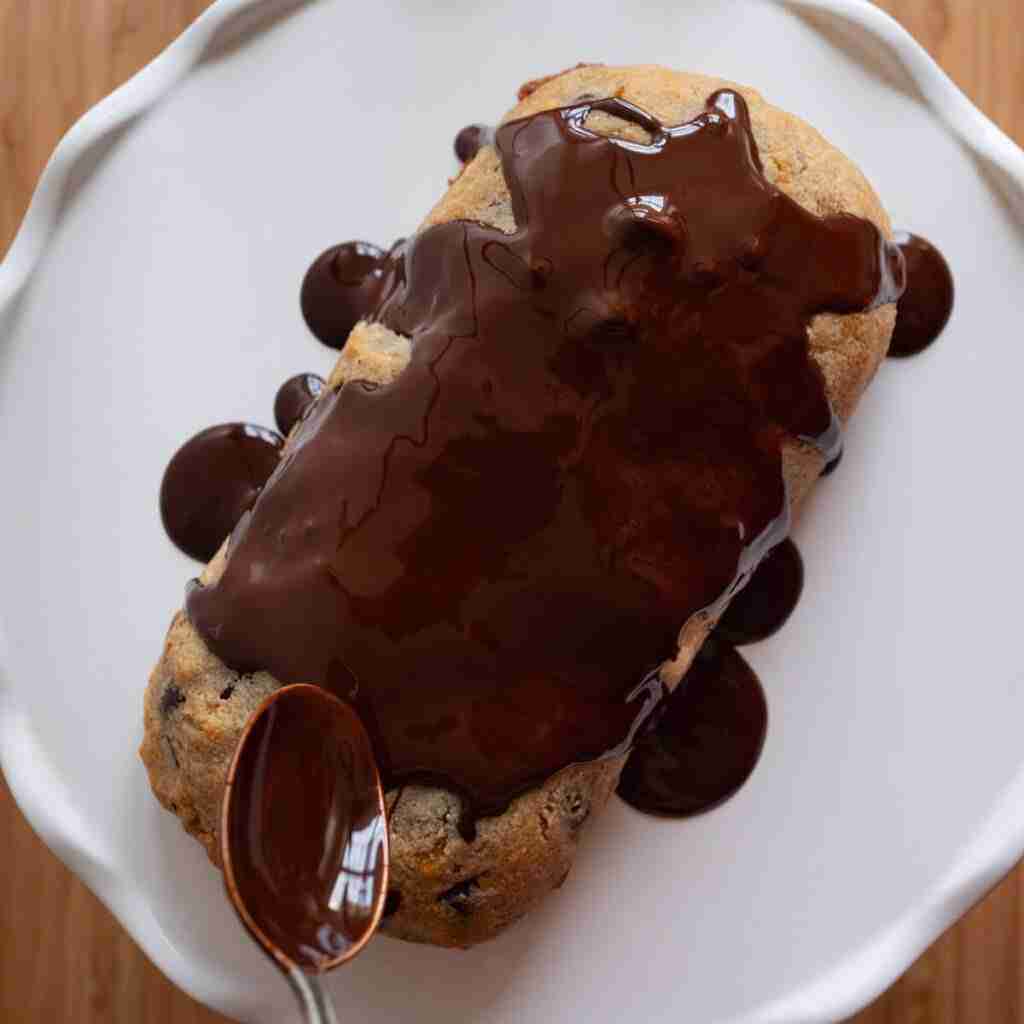 A step in the recipe: Pouring melted dark chocolate on the Chocolate Chip Stollen.