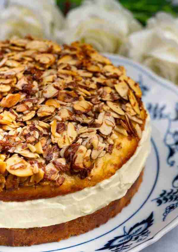 Authentic German Bee Sting Cake: German Bienenstich Cake filled with creamy vanilla pudding on a plate.