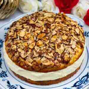 The product of this German Bienenstich recipe: An authentic German bee sting cake with a vanilla cream filling on a plate.