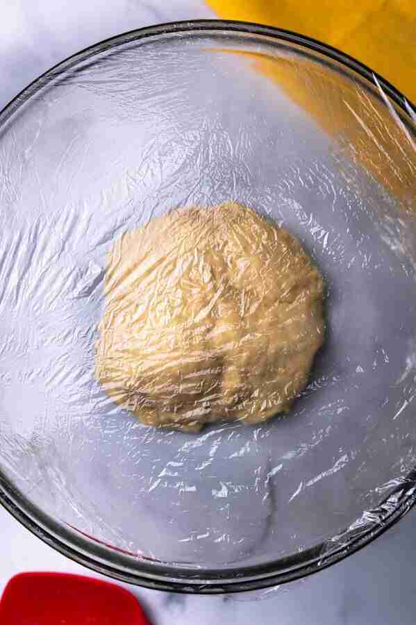 A step in the recipe: Cover the dough with plastic wrap and let it rise.
