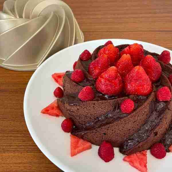 Keto Chocolate Bundt Cake, or sugar free chocolate bundt cake, topped with fresh strawberries and raspberries.