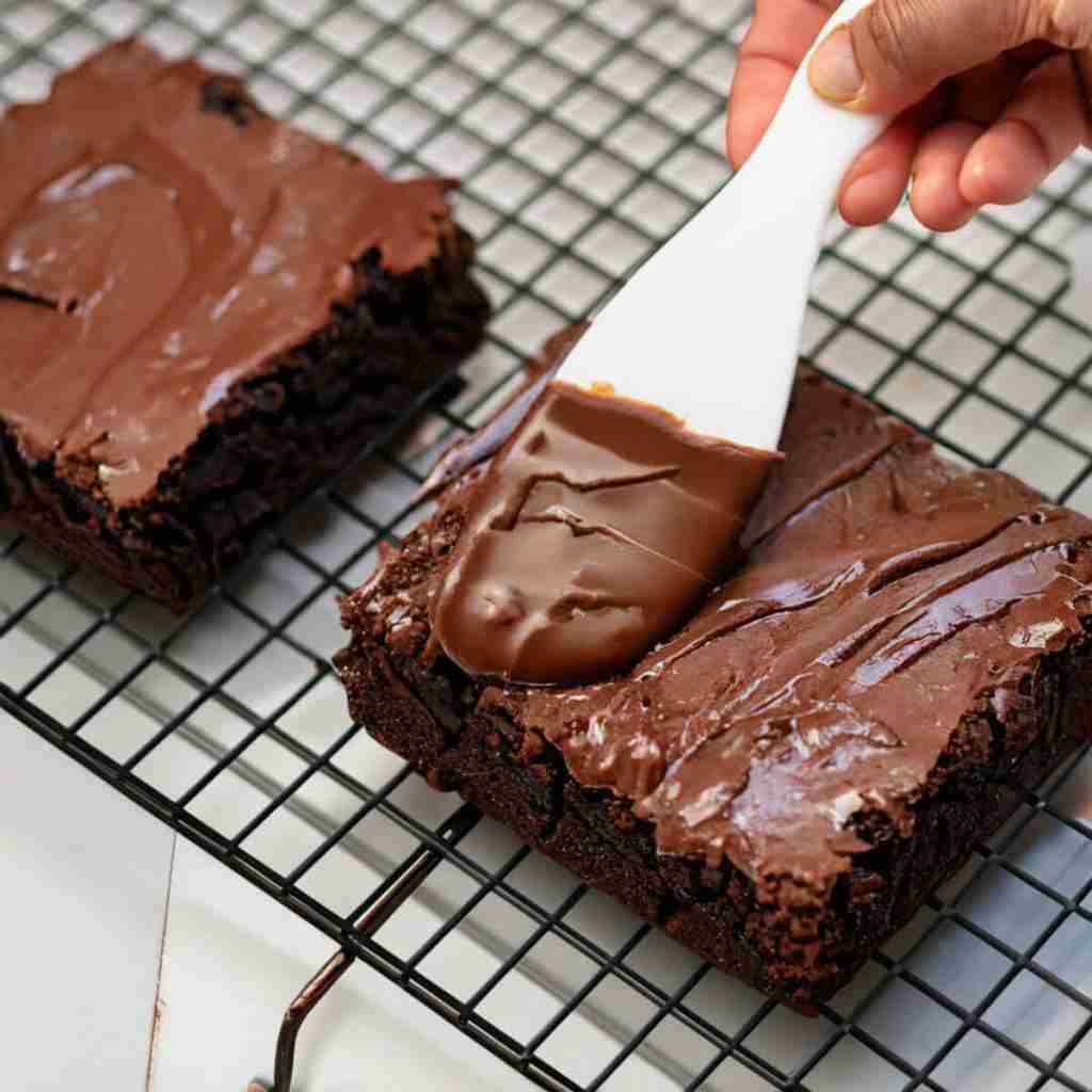 A step in the recipe: Brushing on the chocolate avocado fudge frosting.