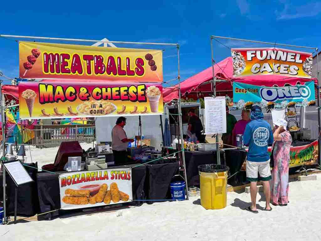 Colorful food trucks on the sand by the sea in Florida.