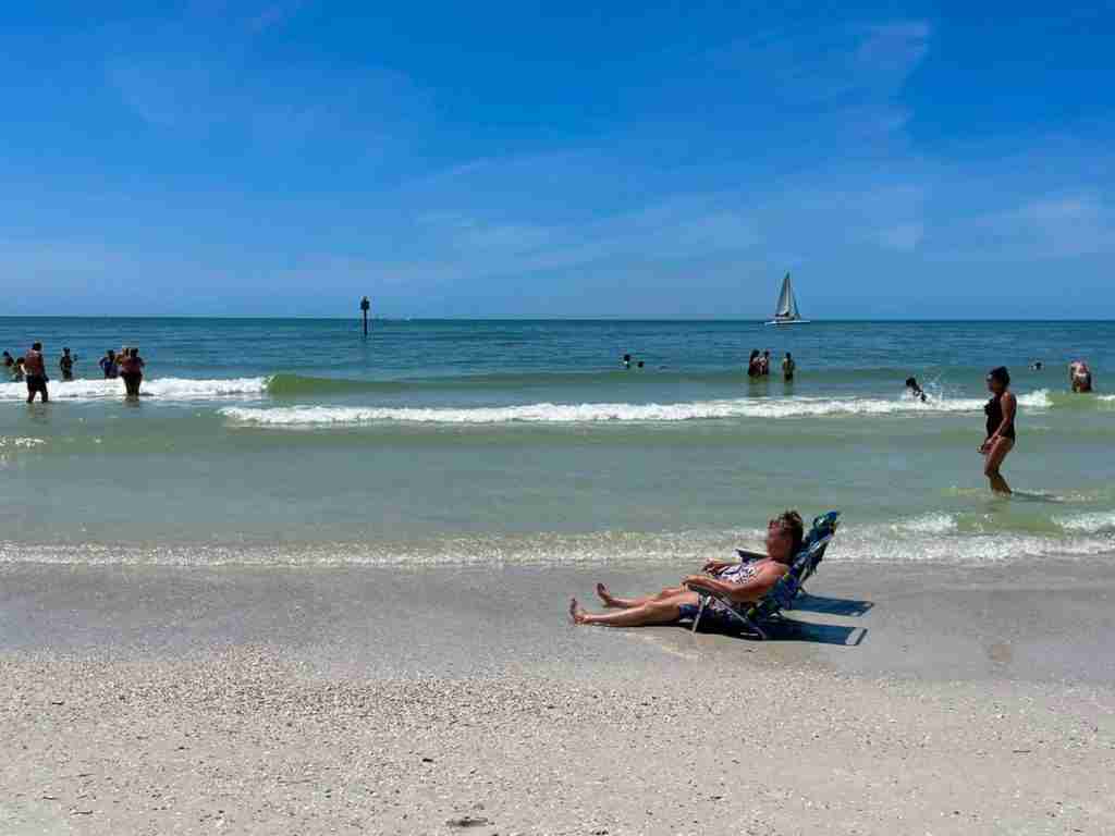 A person sitting at the beach enjoying the sunny day.
