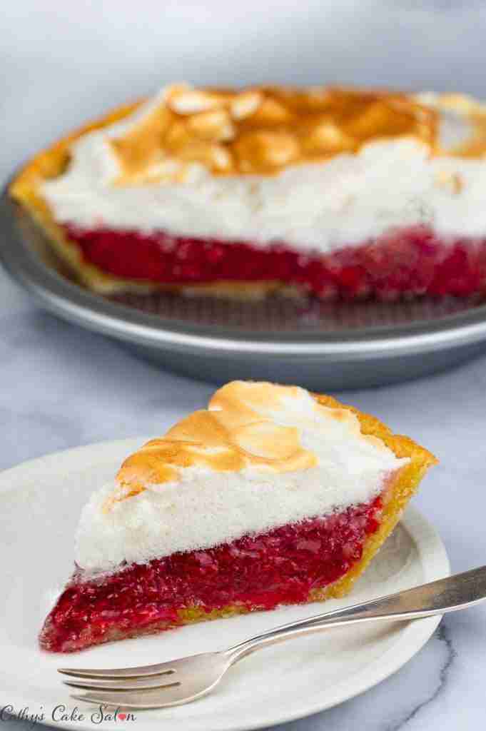 A slice of Cherry Meringue Pie alongside a whole Cherry Meringue Pie made with a sugar free, keto almond flour pie crust.