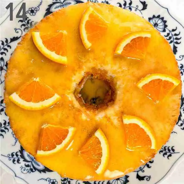 A step in the recipe: The finished orange keto angel food cake topped with sugar free orange glaze and slices of fresh orange.