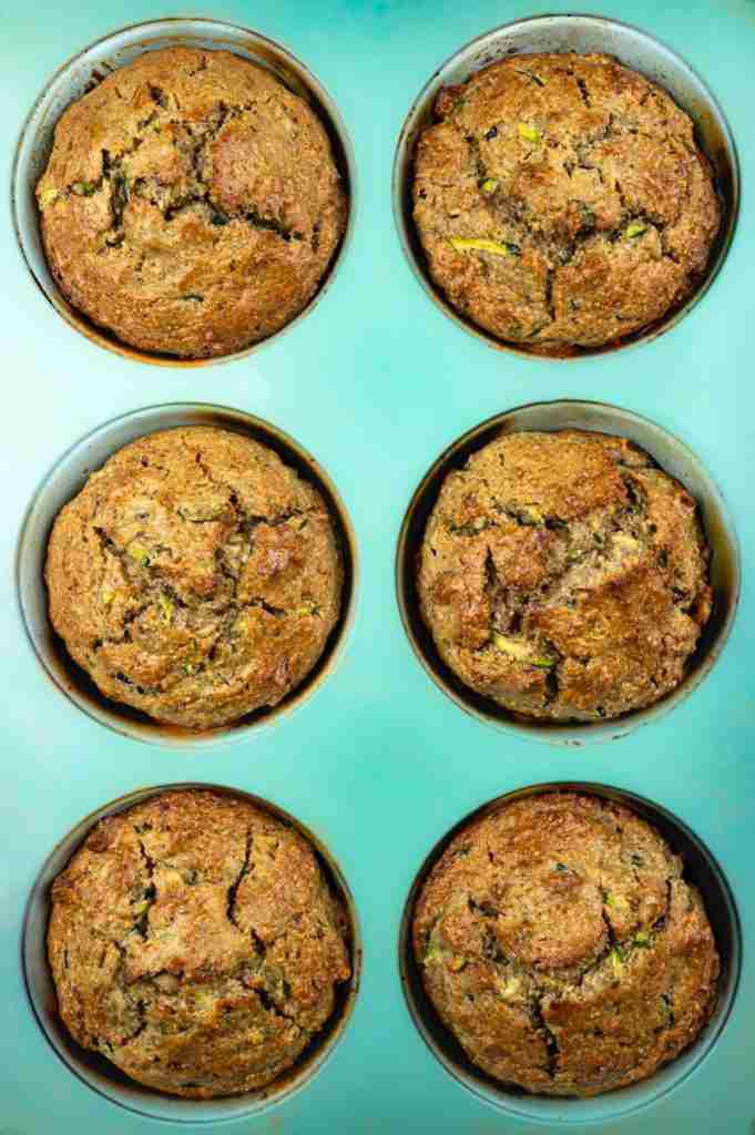 Baked protein zucchini muffins in a blue jumbo muffin tin.