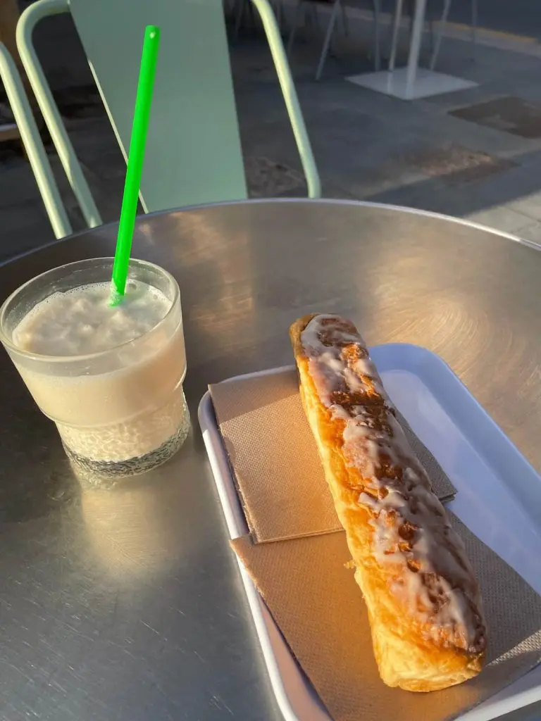 A glass of horchata with a farton pastry in front of Jijonenca ice cream parlor in the Cabanyal, Valencia.