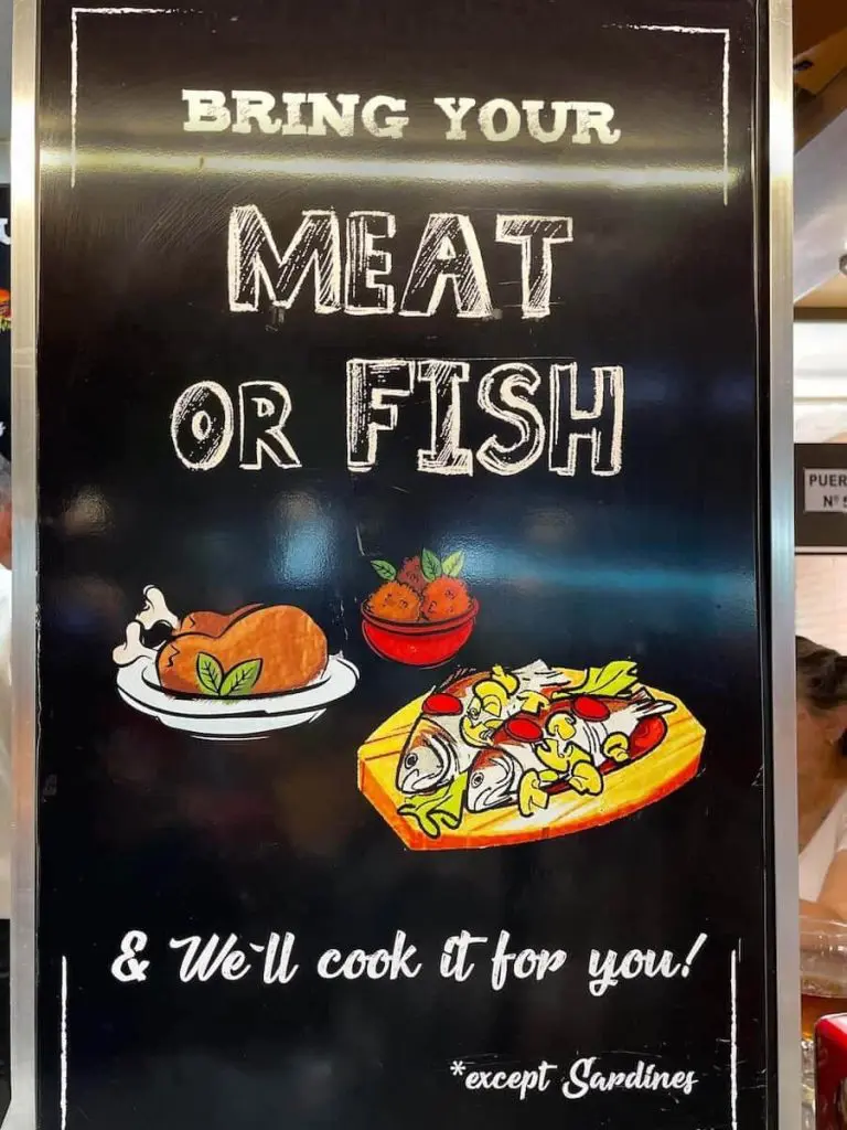 A sign at Bar El Mercado that says that you can bring your meat or fish and they will cook it for you.