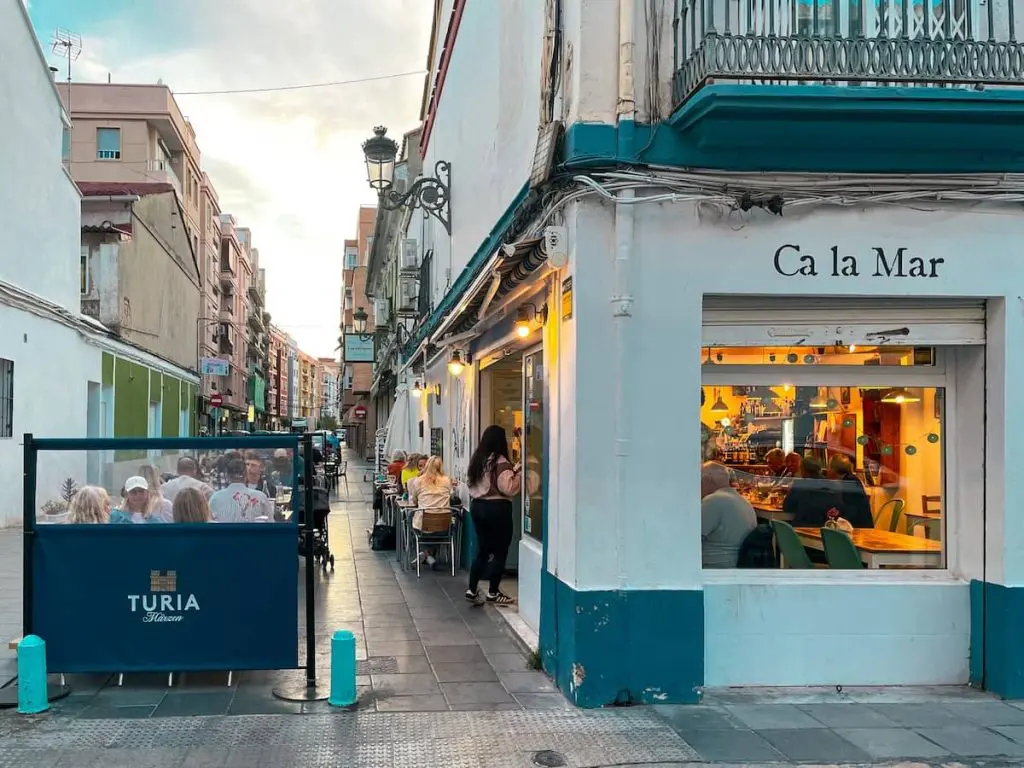 People seated outside of Bar Ca La Mar, one of the best El Cabanyal restaurants in Valencia, Spain.
