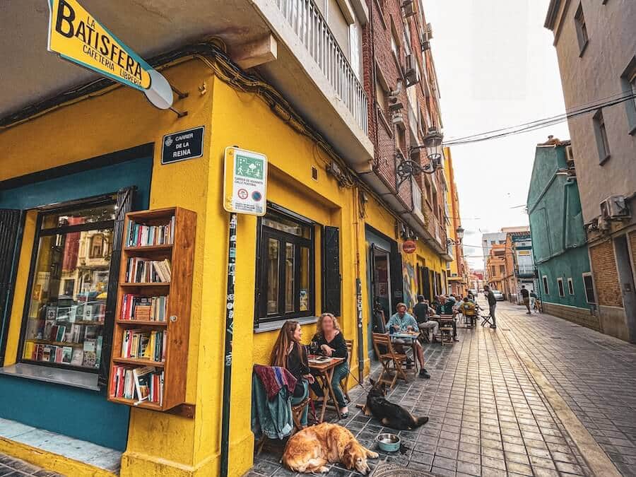 The exterior of La Batisfera which features a bookstore on the corner and a restaurant behind it in El Cabanyal, Valencia, Spain.