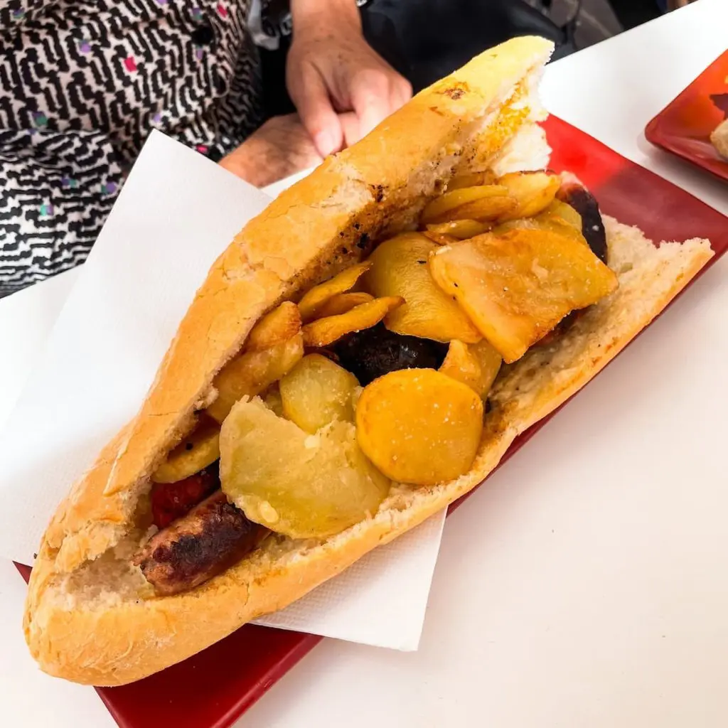 Best Cabanyal restaurants: A sausage and potato bocadillo on a baguette at Bodega La Pascuala restaurant in Valencia.