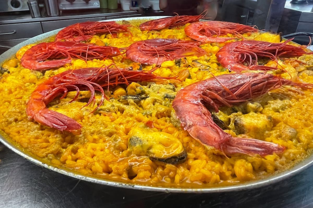 El Cabanyal restaurants feature the best paella such as this one: a seafood paella with large red prawns in one of the El Cabanyal Valencia restaurants.