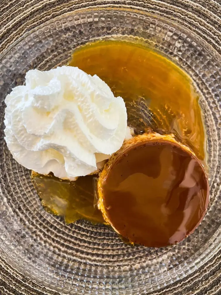 Spanish flan with whipped cream on the side at La Bodeguita del Cabanyal restaurant in Valencia, Spain.
