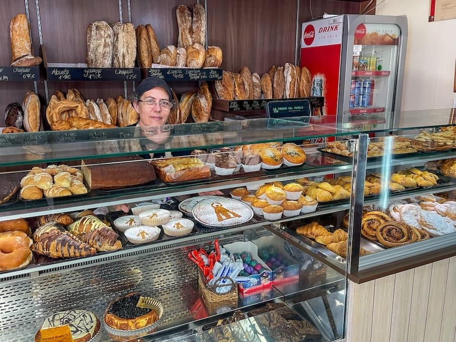 The owner of La Tahona del Abuelo Bakery with her cakes and pastries.