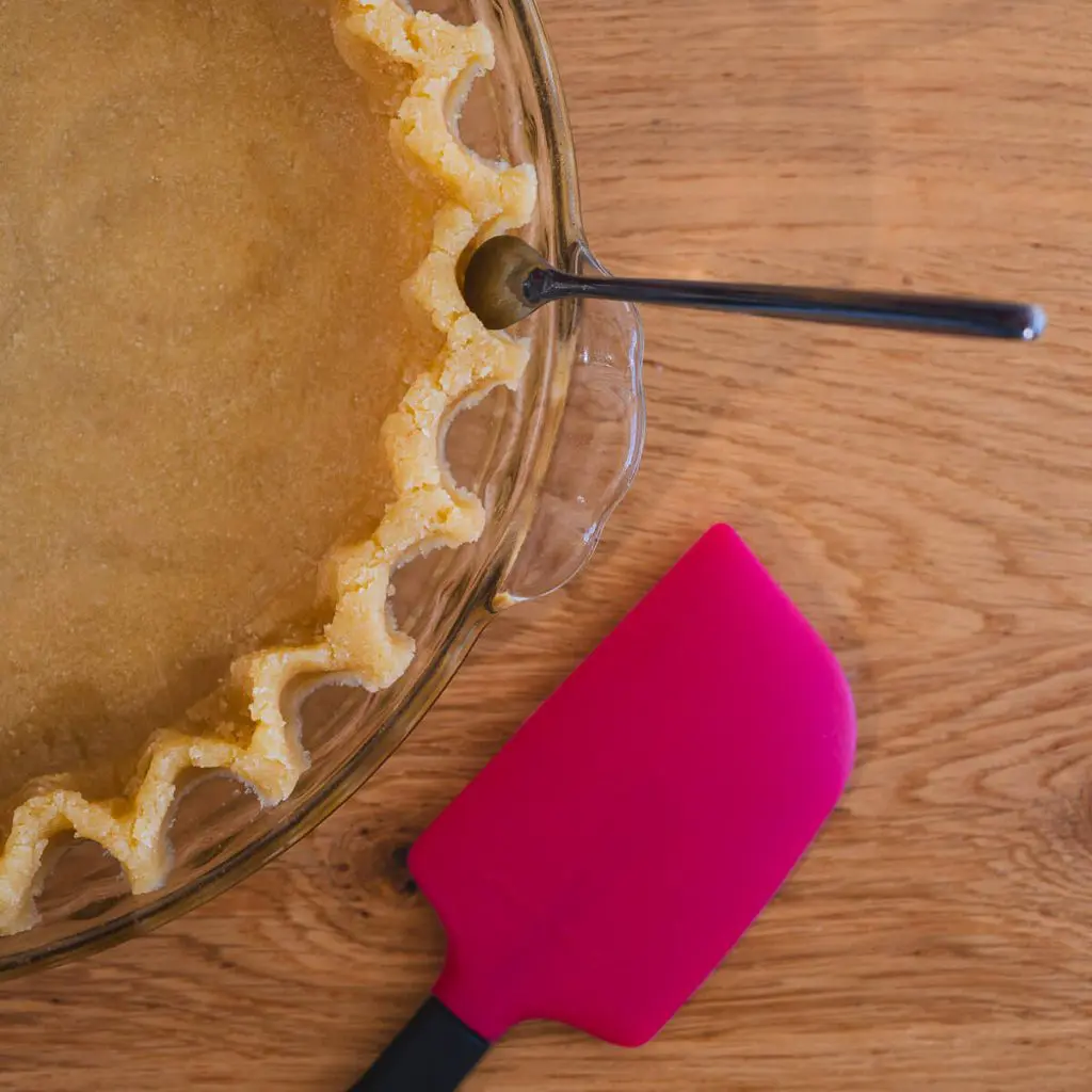 A step in the diabetic recipe: Using a mini spoon to flute the edges of the tart.