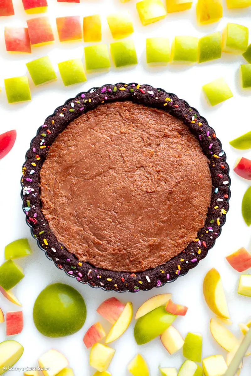 A vegan peanut butter chocolate pie in a sugar free keto chocolate pie crust. The dark chocolate vegan tart shell is filled with colorful sprinkles.