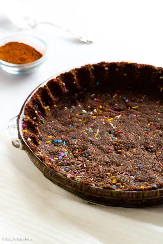 The result of this keto chocolate pie crust recipe with colorful sprinkles: a baked chocolate keto pie crust.