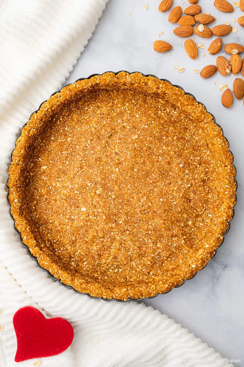 The result of this oat flour pie crust recipe: A baked, golden brown oat flour tart crust in a fluted tart pan.