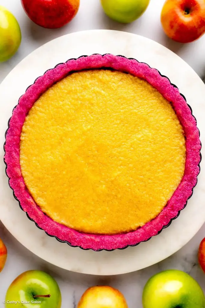A gluten free apple tart featuring monk-fruit sweetened apple curd in a magenta dragon fruit almond flour pie crust.