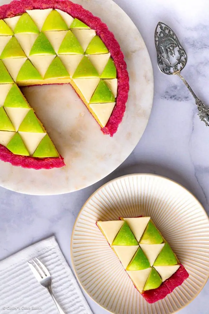 The sugar free, gluten free apple curd tart in a magenta gluten free tart crust with a slice on a plate next to it.