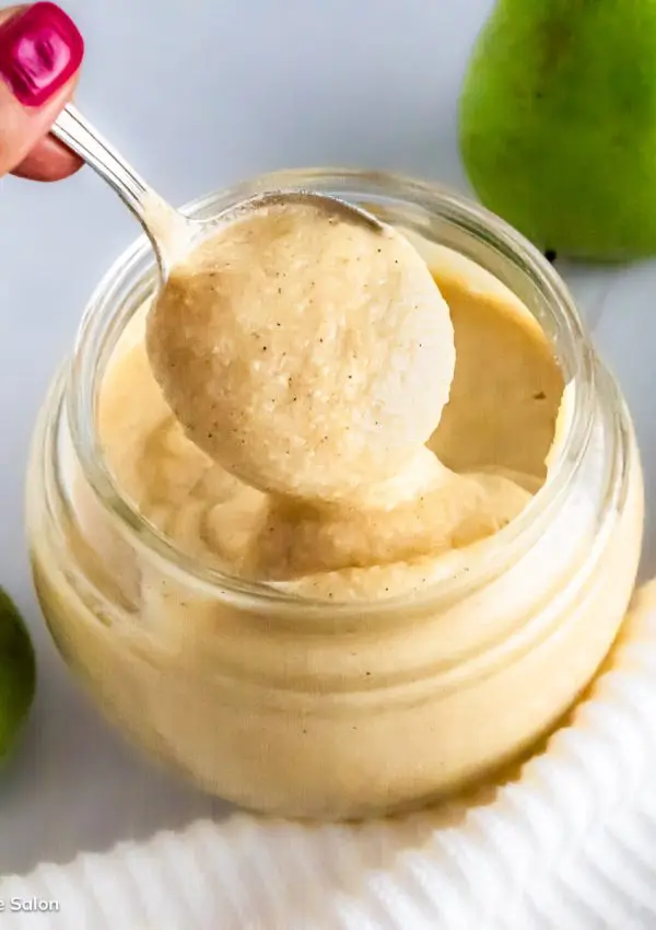 Homemade pear curd drizzling from a spoon.