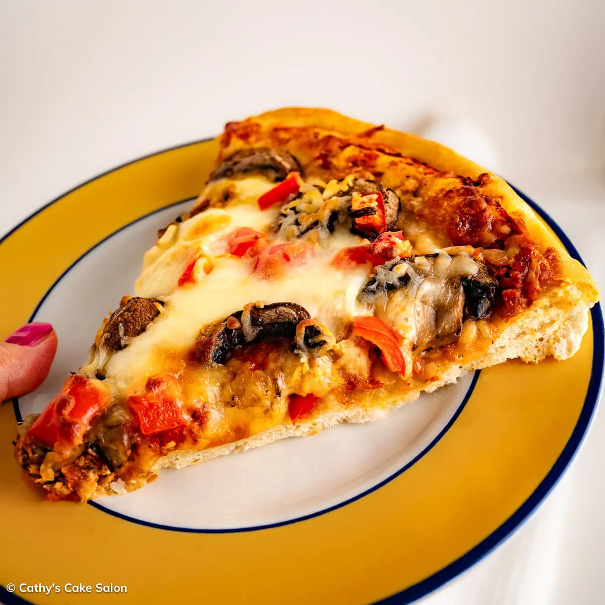 A slice of sugar free pizza topped with mushrooms and red bell peppers.