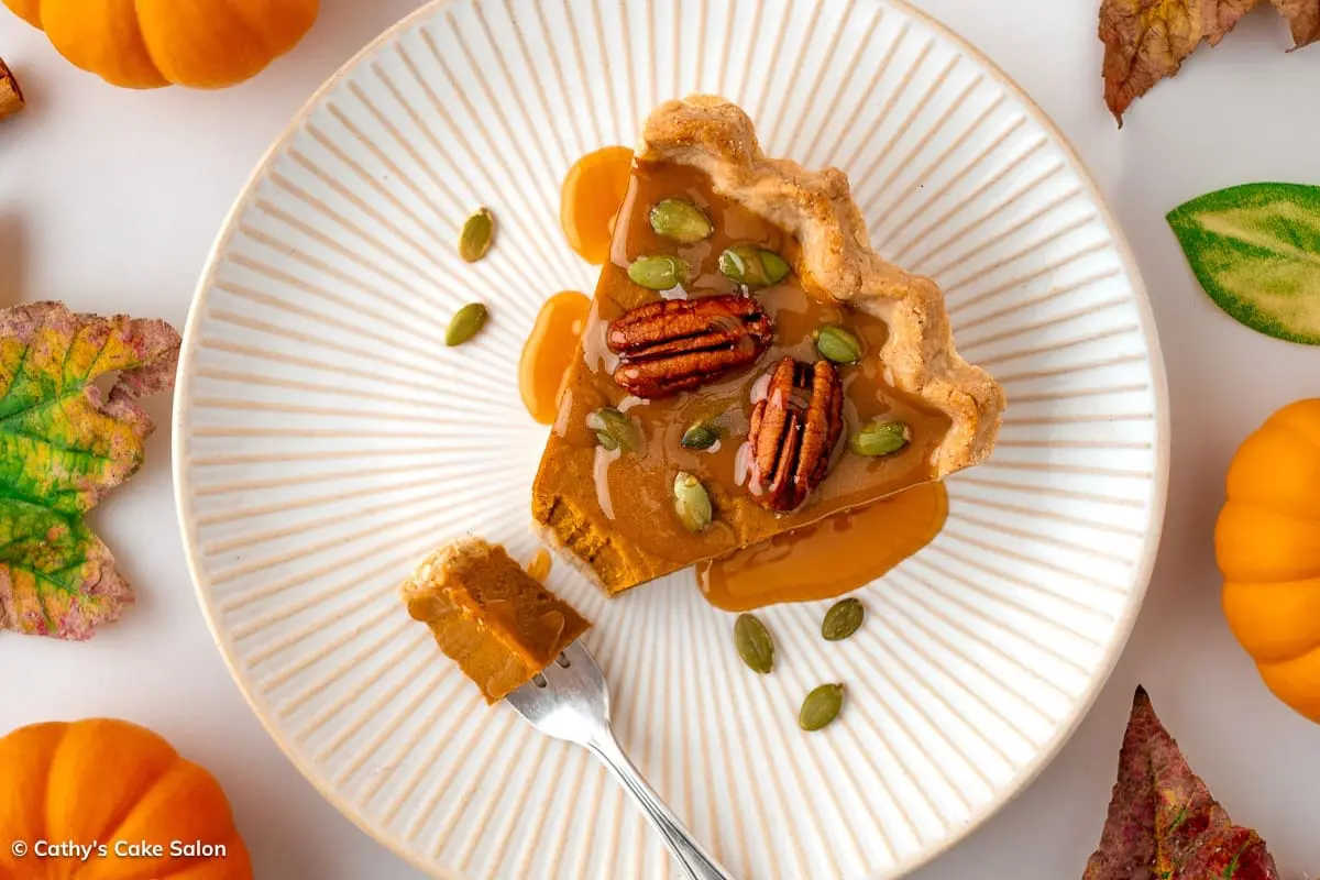 A slice of vegan pumpkin tart topped with homemade gluten free pumpkin sauce.