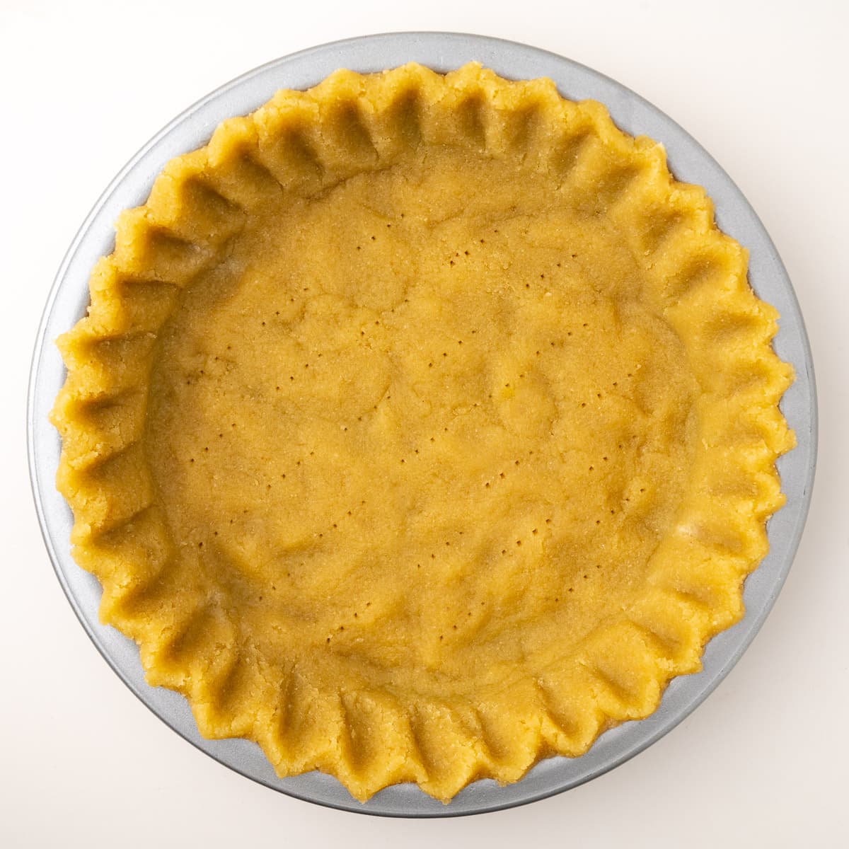 A step in the recipe: Prick the unbaked, sugar free almond flour pie crust.