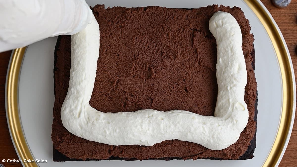 A step in the recipe: Pipe white chocolate mousse onto the chocolate mousse.