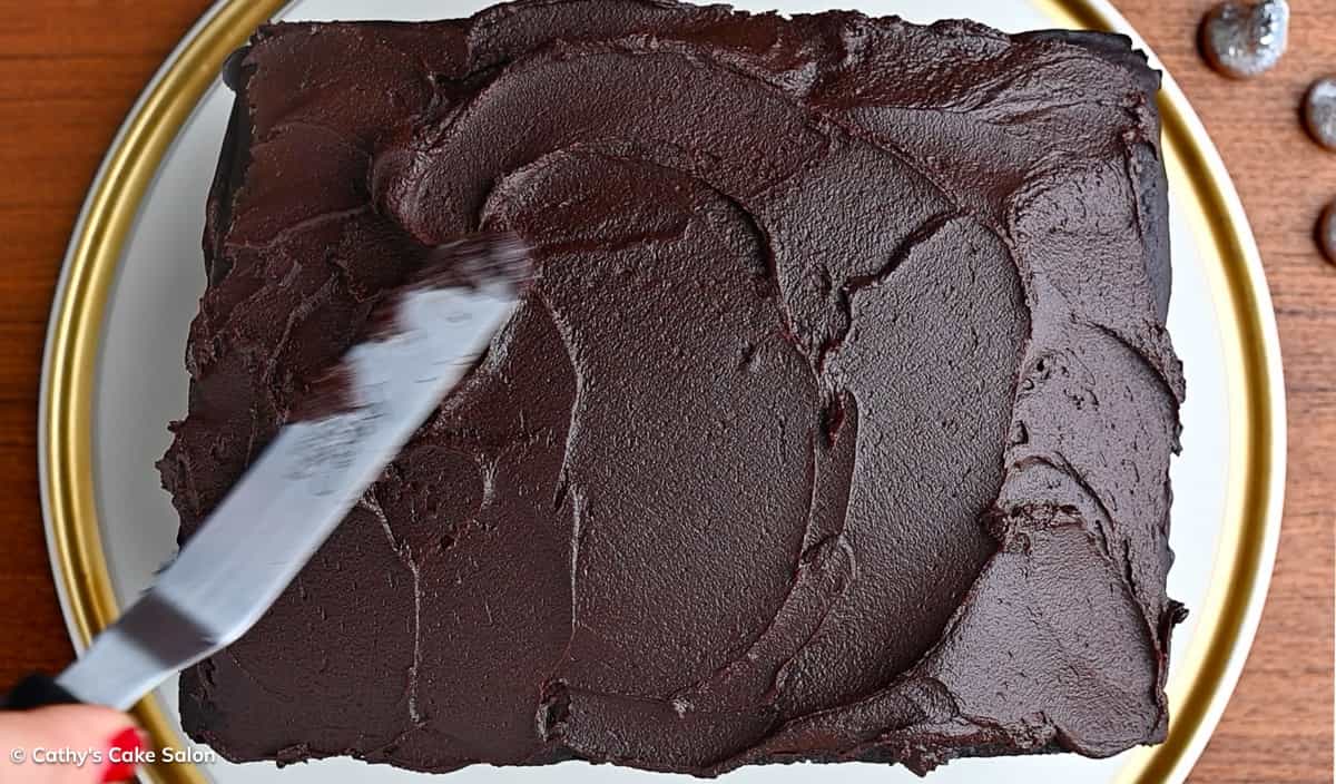 A step in the recipe: Frost the top of the cake with chocolate ganache.