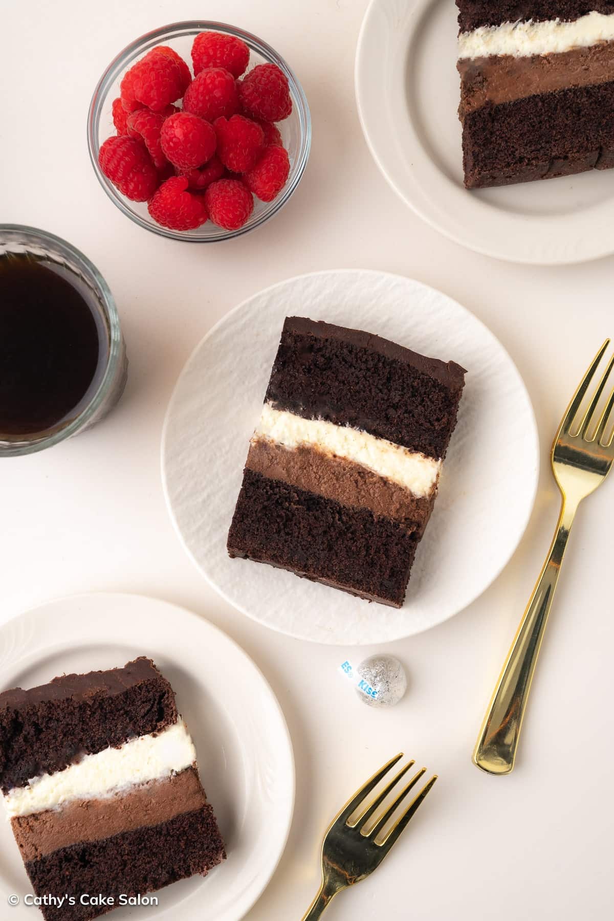 Slices of Costco tuxedo cake topped with creamy chocolate ganache on a plate.
