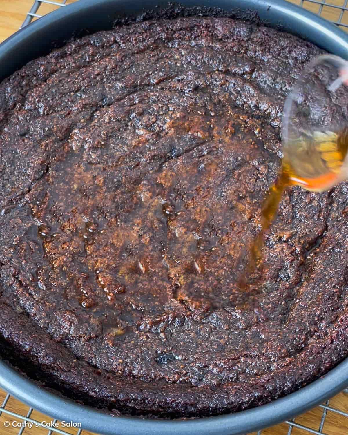 A step in the recipe: Pour dark rum over the baked cake.