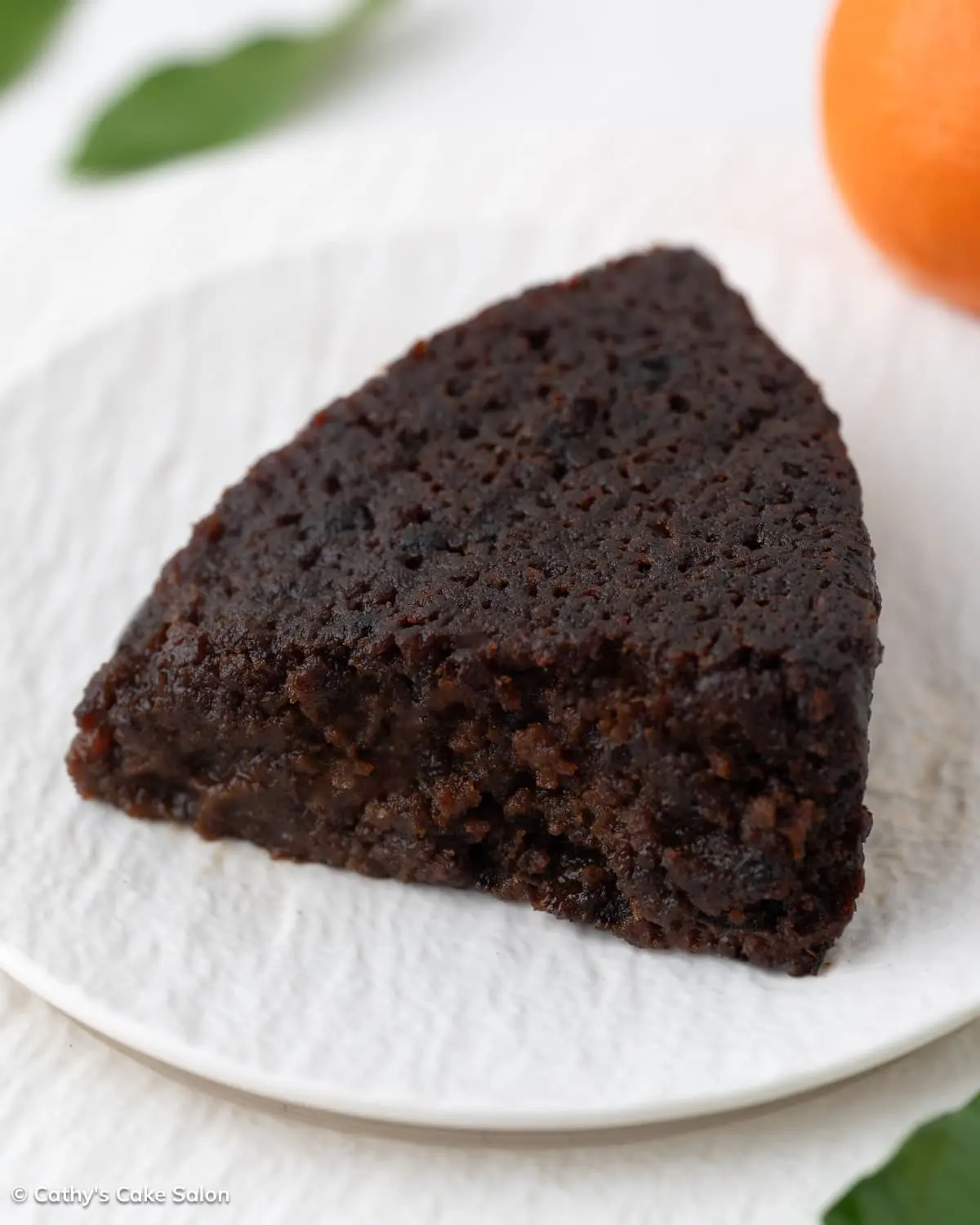 A slice of this boozy Guyanese black cake filled with fruits, rum, and wine.