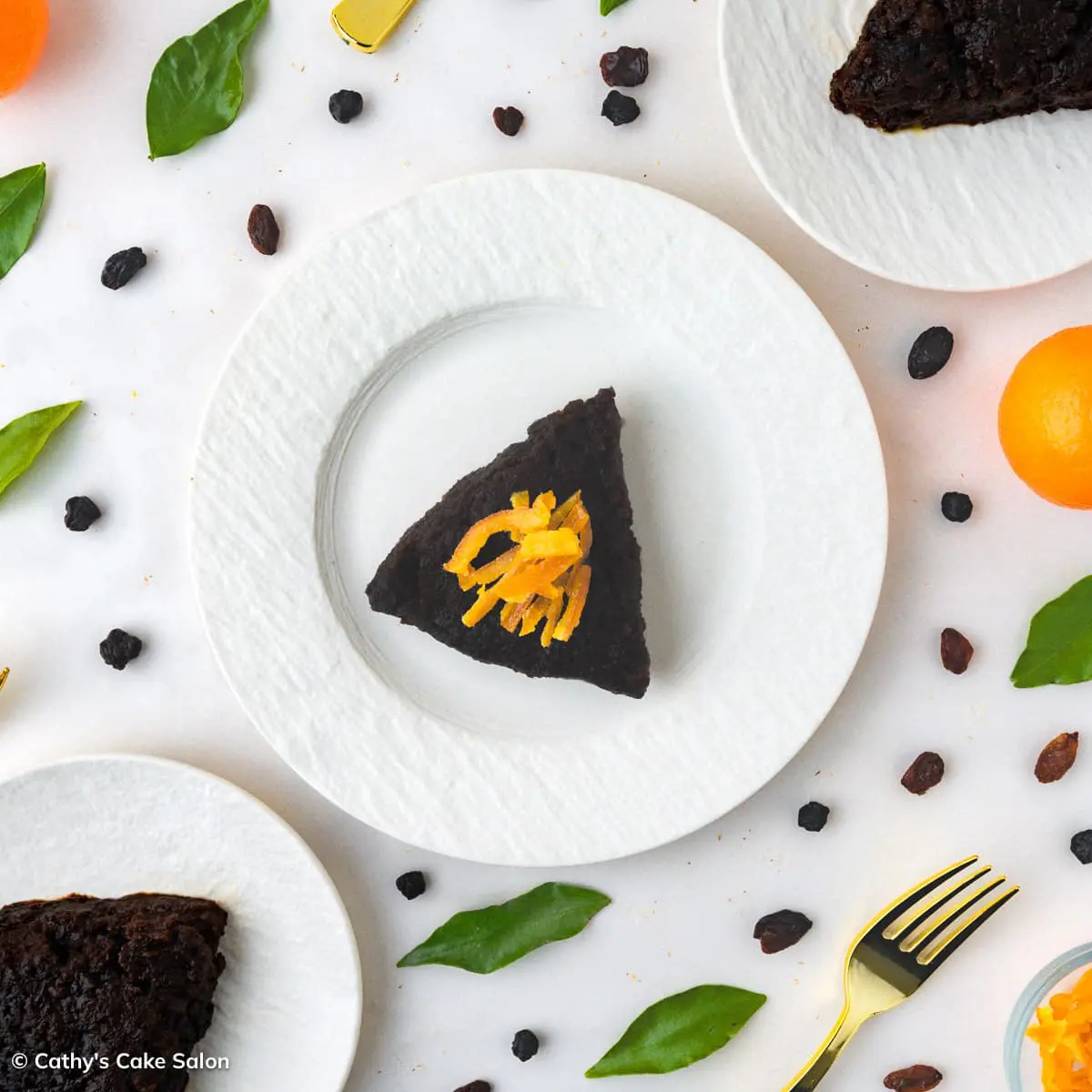 Slices of boozy Caribbean black cake topped with homemade candied orange peel.