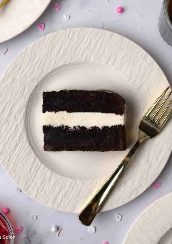 A slice of a homemade dark chocolate Hostess Suzy Q snack cake with a creamy marshmallow buttercream filling.